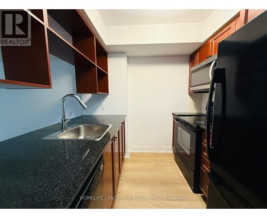 A kitchen with dark brown cabinets and a black countertop.