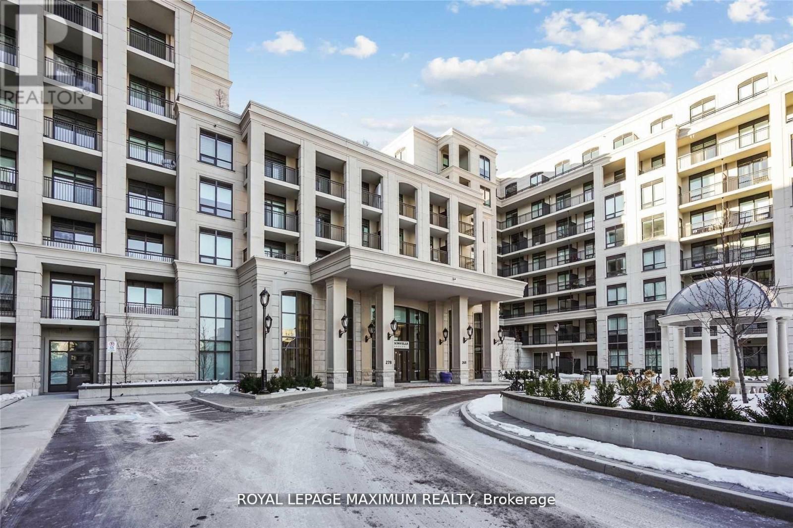 A large, modern building with a curved entrance and a sign that reads "Royal LePage Maximum Realty, Brokerage.".