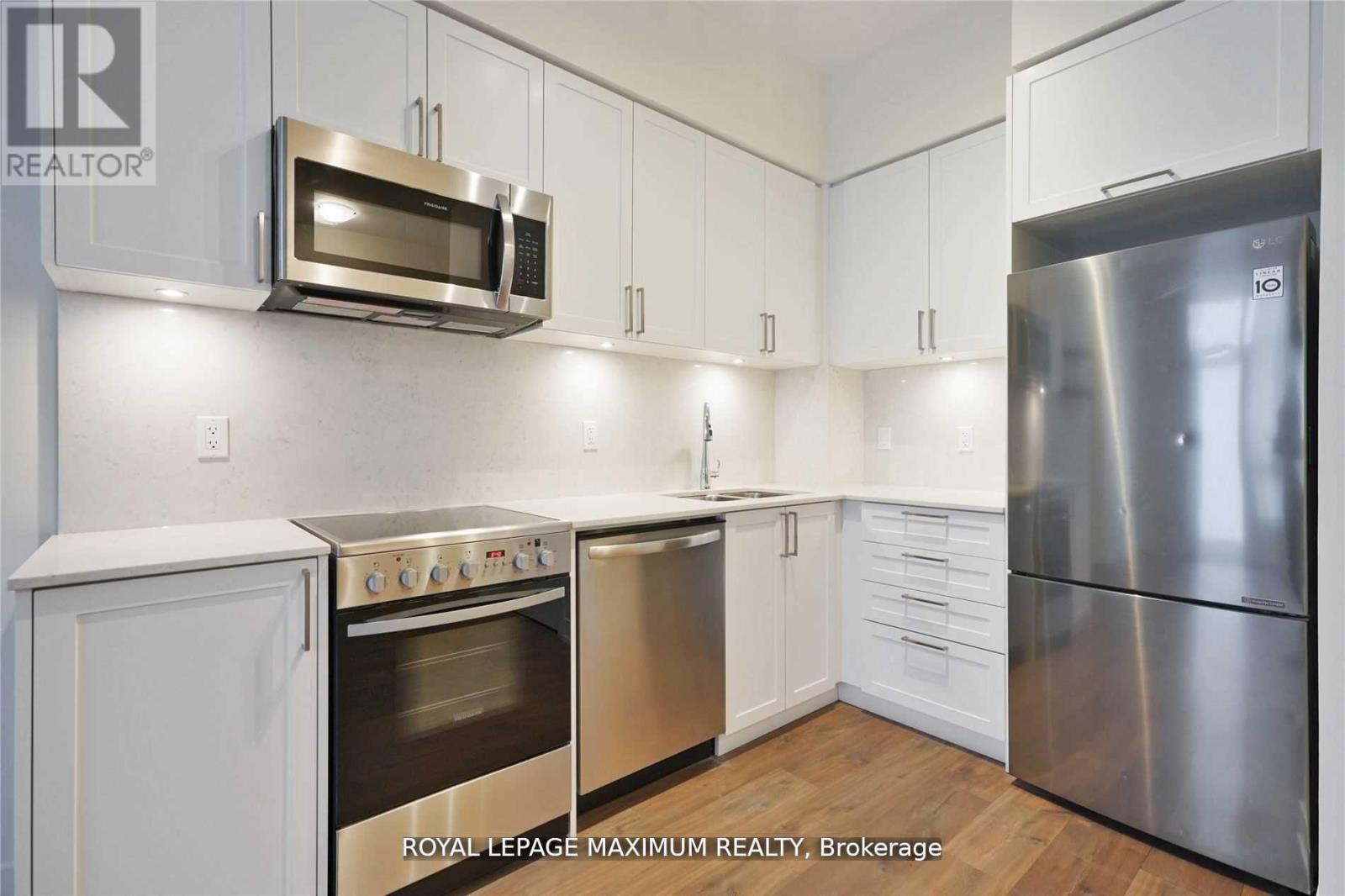 A kitchen with white cabinets and stainless steel appliances.