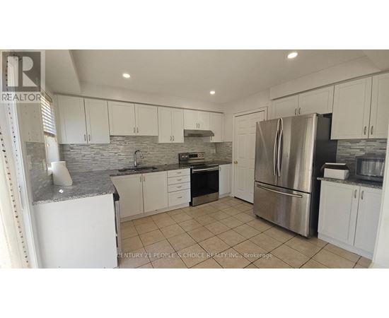 A kitchen with white cabinets and a stone backsplash.