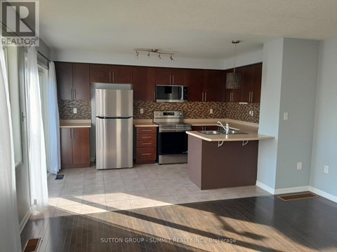 A kitchen with brown cabinets and a white refrigerator.