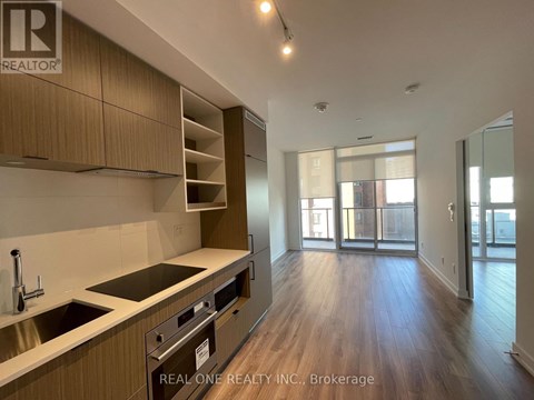 A kitchen with wooden cabinets and a stainless steel sink.