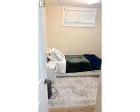 A bedroom with a bed, pillows, and a rug.