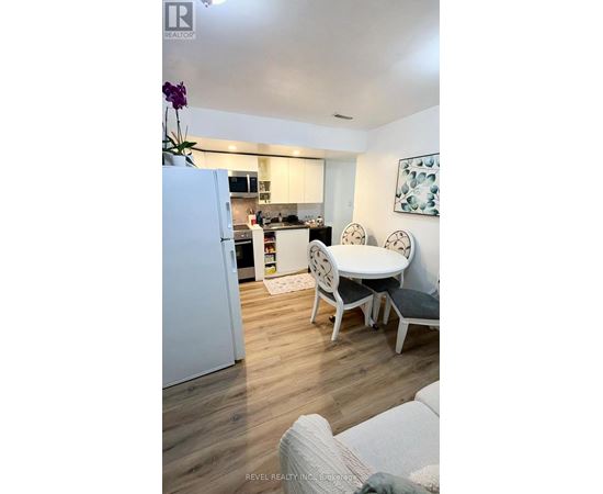 A white refrigerator is in a kitchen with a table and chairs.