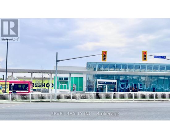 A bus is parked in front of a building with the word "REVEL" on it.