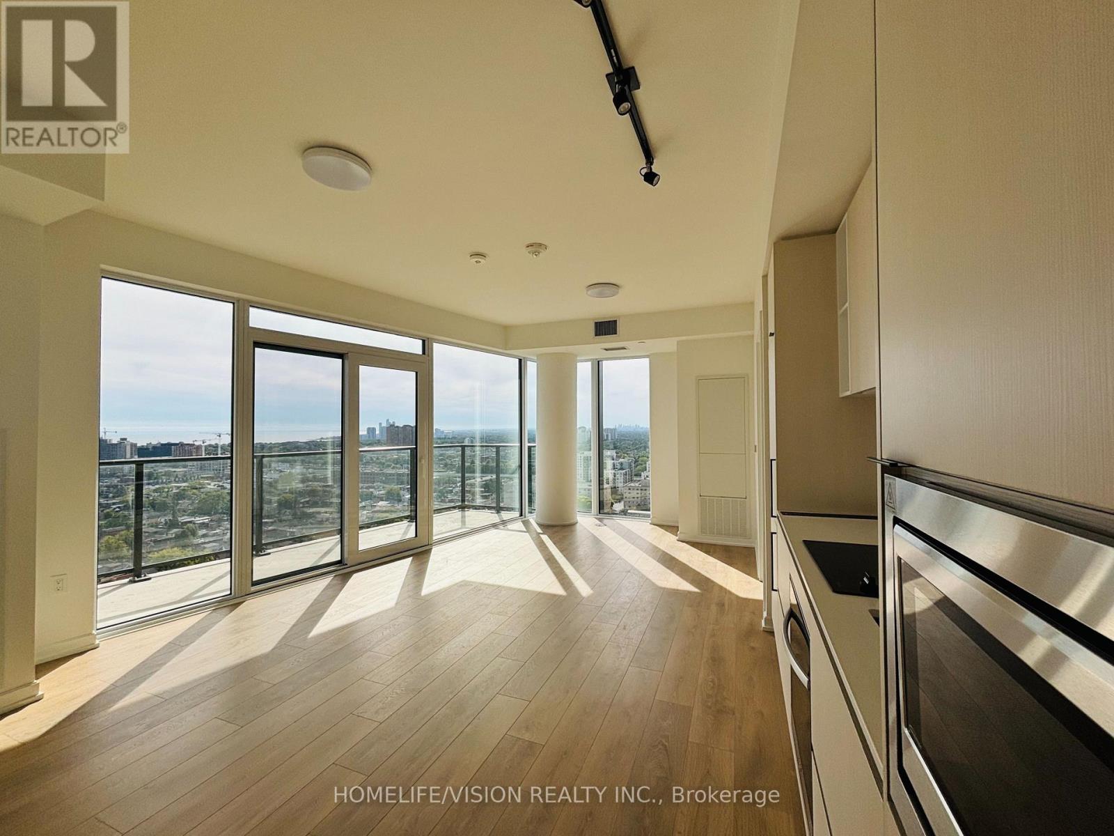 A spacious kitchen with wooden floors and stainless steel appliances.
