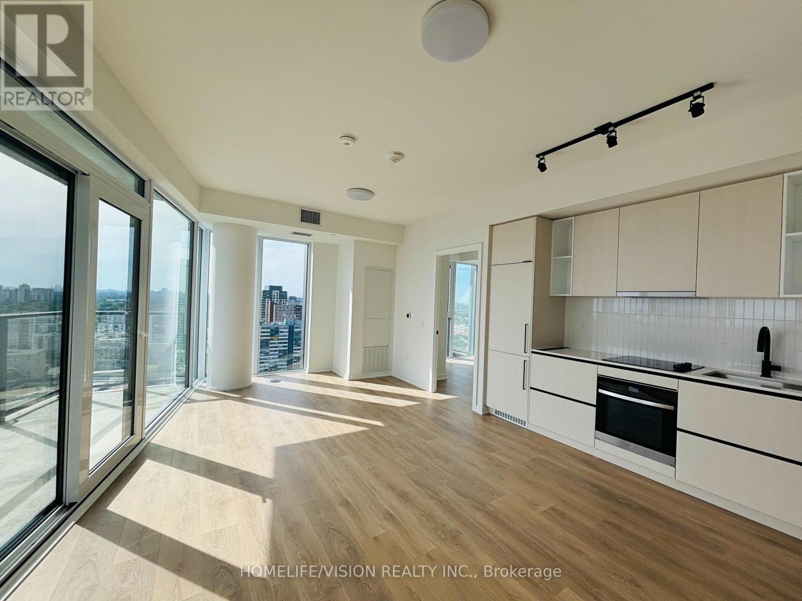 A spacious kitchen with white cabinets and a stainless steel oven.