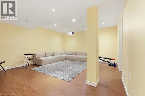 A living room with a grey rug and a sofa.