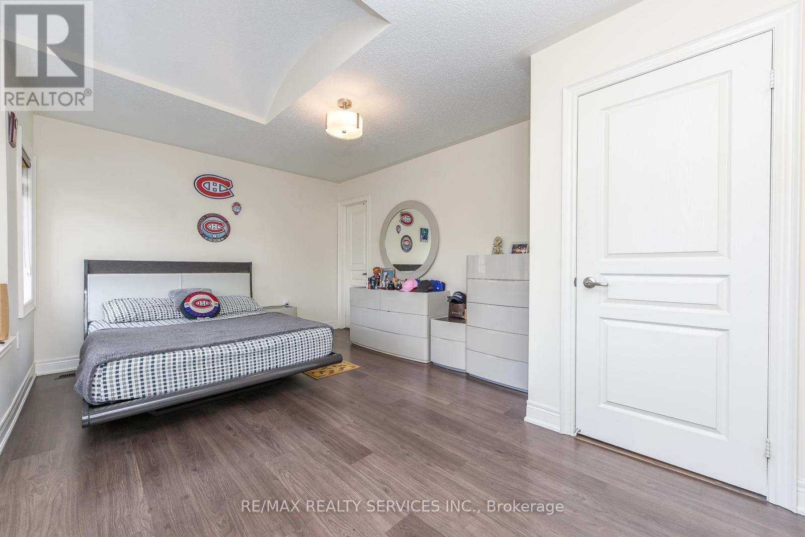 A bedroom with a bed, dresser, and mirror.