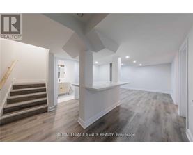 A spacious room with wooden flooring and white walls.