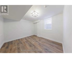 A room with wooden flooring and white walls.