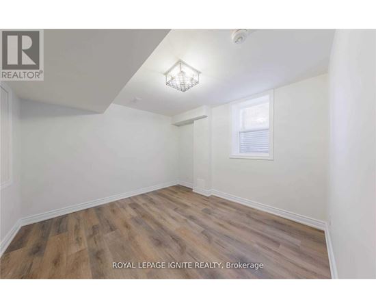 A room with wooden flooring and white walls.