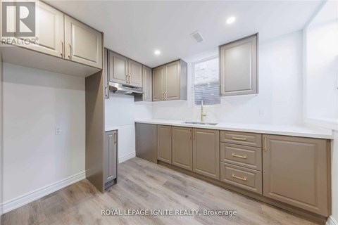 A kitchen with beige cabinets and a white countertop.