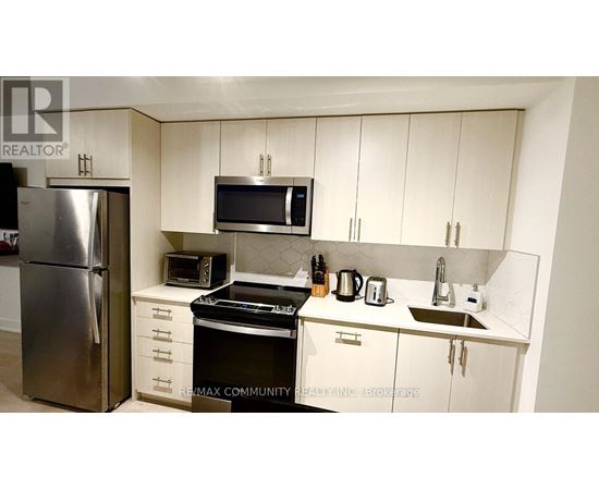 A kitchen with white cabinets and a stainless steel refrigerator.