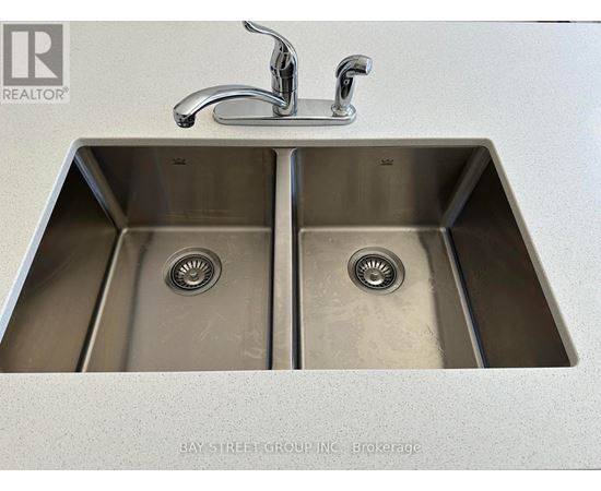 A double sink in a kitchen with a faucet above it.