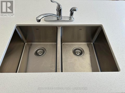 A double sink in a kitchen with a faucet above it.