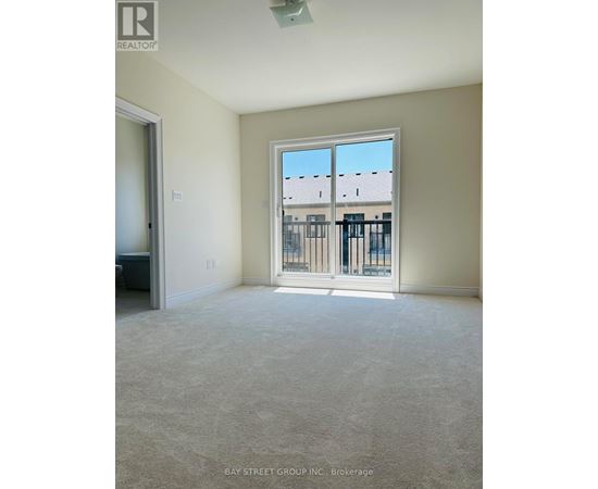 A room with a large window and a view of a building across the street.
