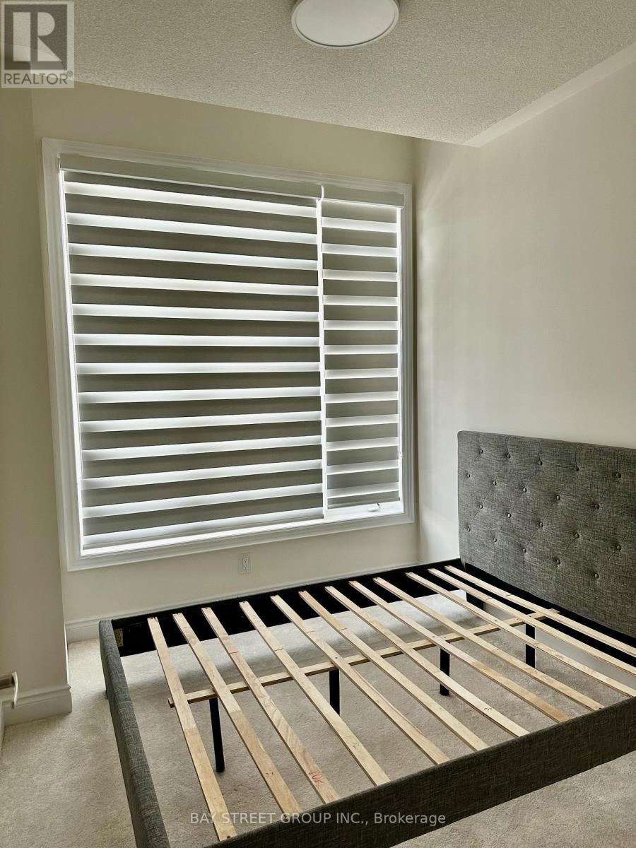 A bedroom with a bed, window with blinds, and a headboard.