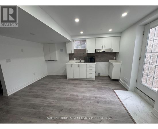 A spacious kitchen with white cabinets and a wooden countertop.