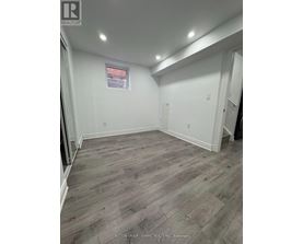 A room with wooden flooring and white walls.