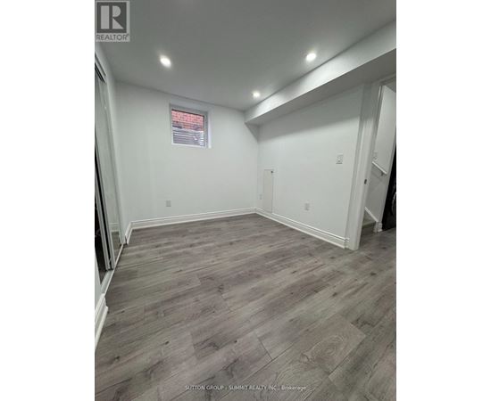 A room with wooden flooring and white walls.