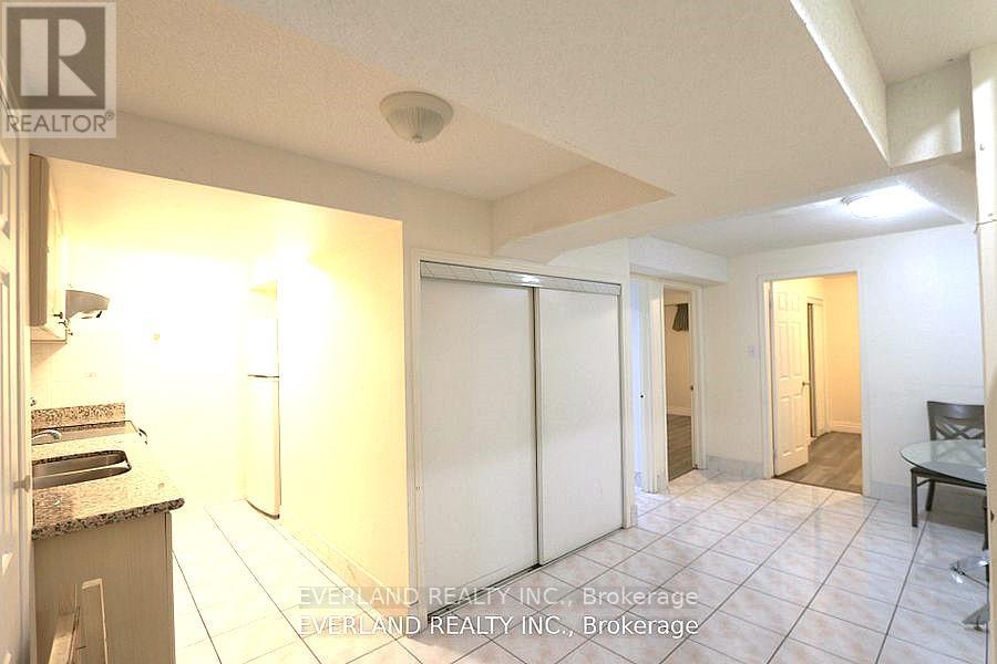A realtor photo of a kitchen with a refrigerator, sink, and a dining table.