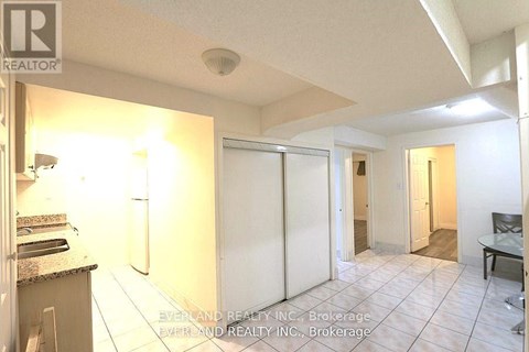 A realtor photo of a kitchen with a refrigerator, sink, and a dining table.