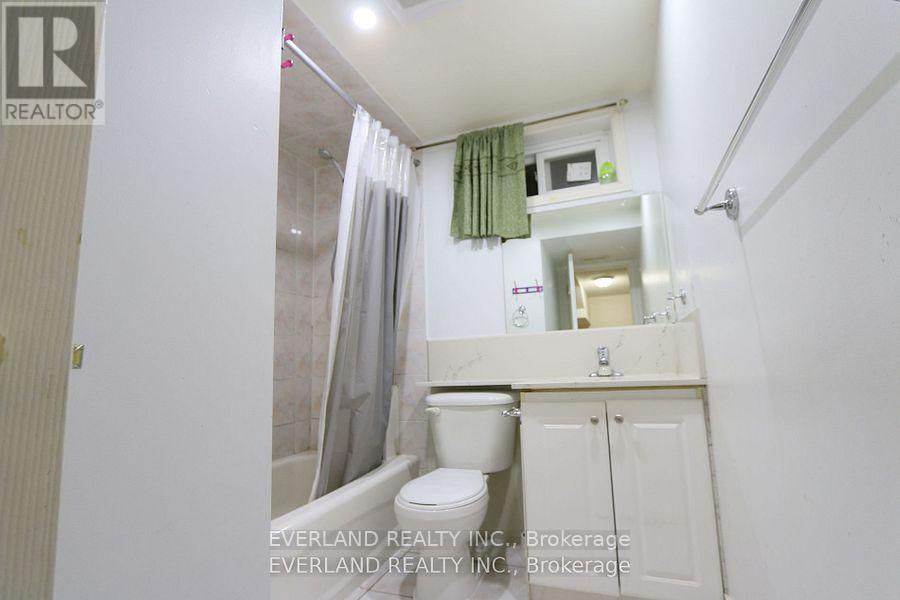 A small bathroom with a toilet, sink, and shower.