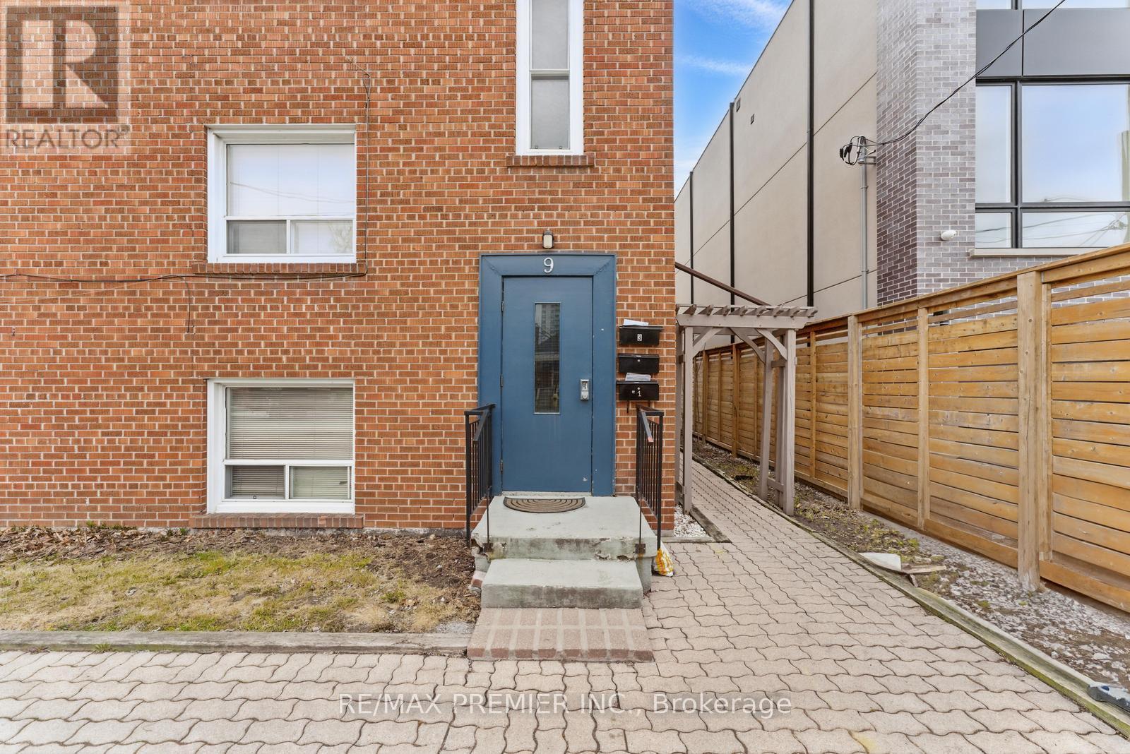 A brick building with a blue door and a sign that says REALTOR.