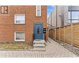A brick building with a blue door and a sign that says REALTOR.