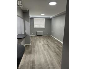 A room with grey walls and a wooden floor.
