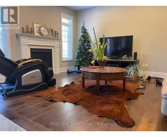 A living room with a fireplace, a television, and a Christmas tree.