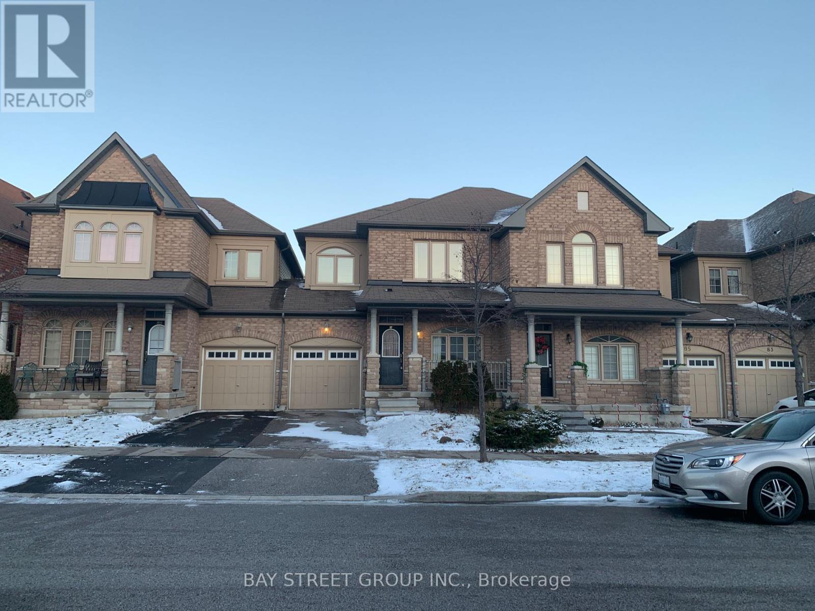 A large, multi-story house with a car parked in front.