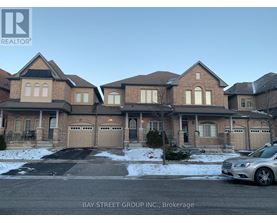 A large, multi-story house with a car parked in front.