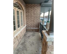 A patio area with a brick wall and a window.