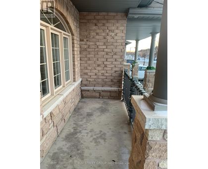A patio area with a brick wall and a window.
