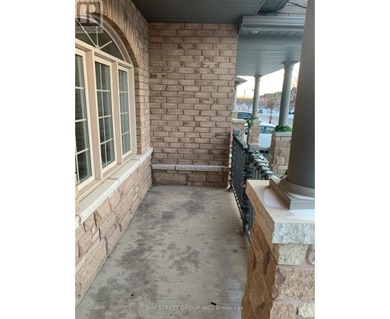 A patio area with a brick wall and a window.