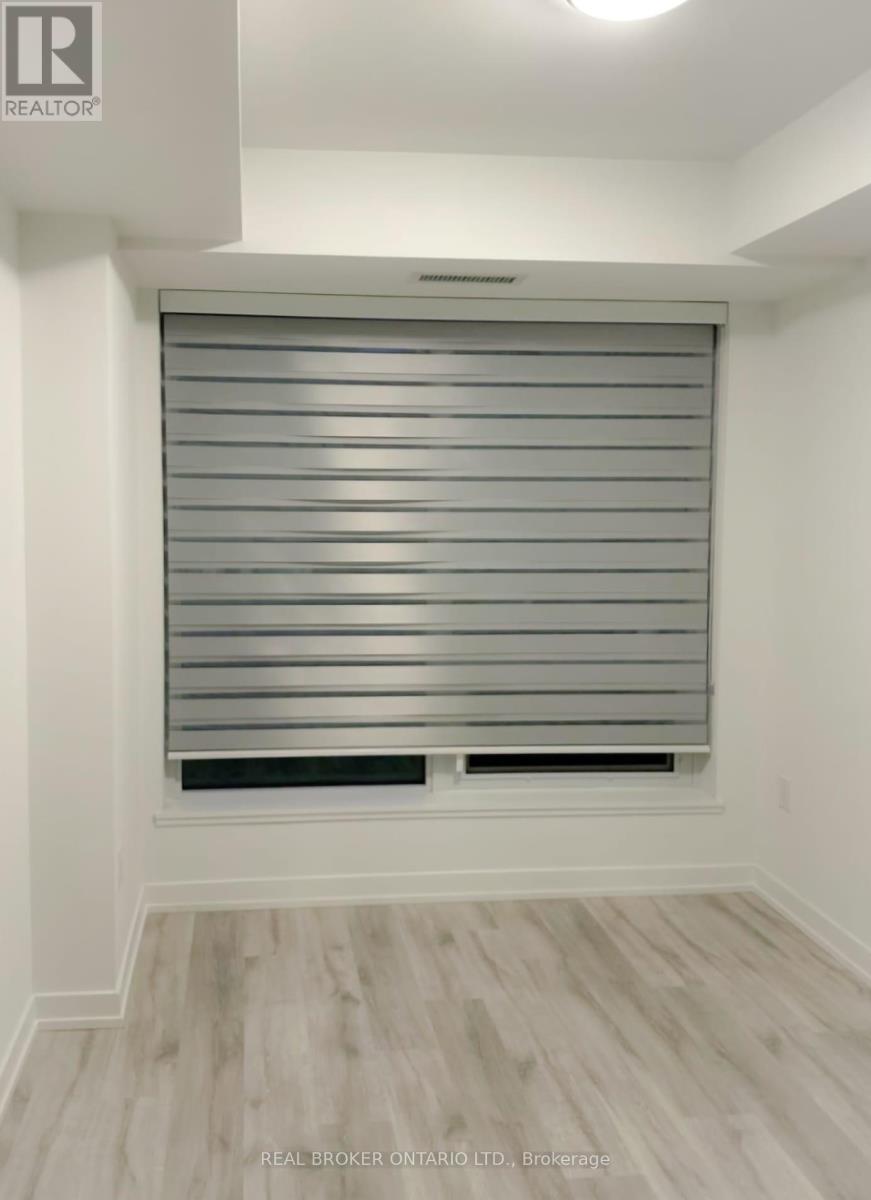 A room with a window covered by horizontal blinds.