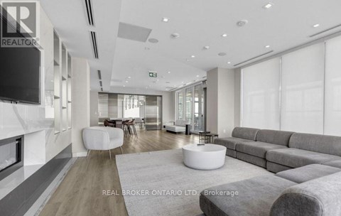 A modern living room with a grey sofa and a white coffee table.