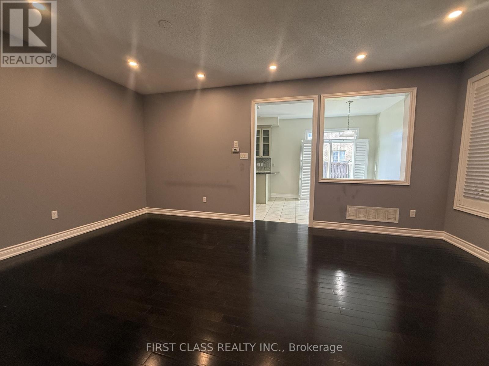 A spacious living room with a fireplace and a skylight.