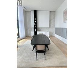A modern dining room with a black table and chairs.