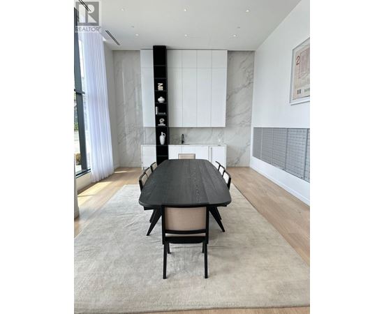 A modern dining room with a black table and chairs.