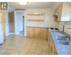 A kitchen with a refrigerator, sink, and cabinets.