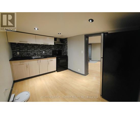 A kitchen with wooden floors and a black counter top.