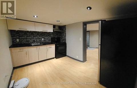 A kitchen with wooden floors and a black counter top.