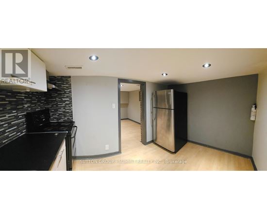 A kitchen area with a refrigerator and a counter.