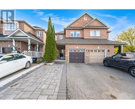 A large house with a driveway and two cars parked in front.