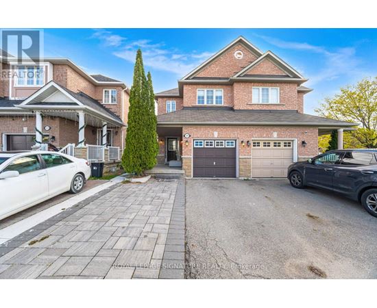 A large house with a driveway and two cars parked in front.