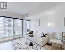 A modern living room with a large window and a view of a building outside.