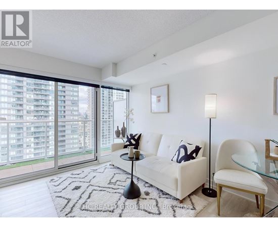 A modern living room with a large window and a view of a building outside.